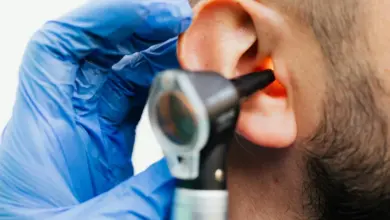 Otolaryngolog zkouší ucho pacienta pomocí otoskopu.