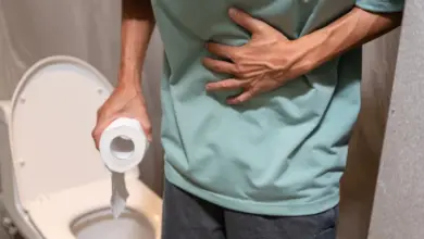Muž drží toaletní papír a stiská si břicho kvůli průjmu.