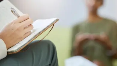 Psycholog zapisuje poznámky během sezení s klientem.