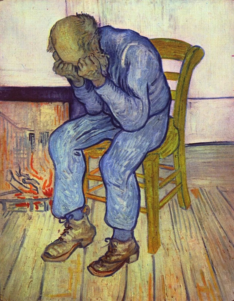Muž sedící u krbu s rukama na obličeji v modrém oblečení.