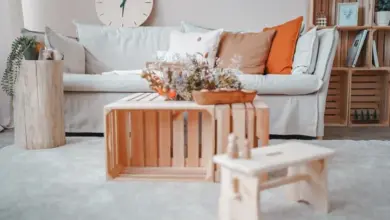 Skandinávský obývací pokoj s bílou pohovkou a dřevěným stolem.