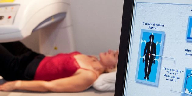 Pacientka v tomografu s monitorem ukazujícím polohování páteře.