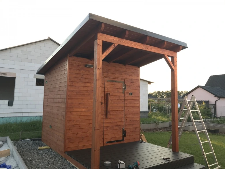 Venkovní dřevěná sauna v procesu stavby s otevřenou terasou.