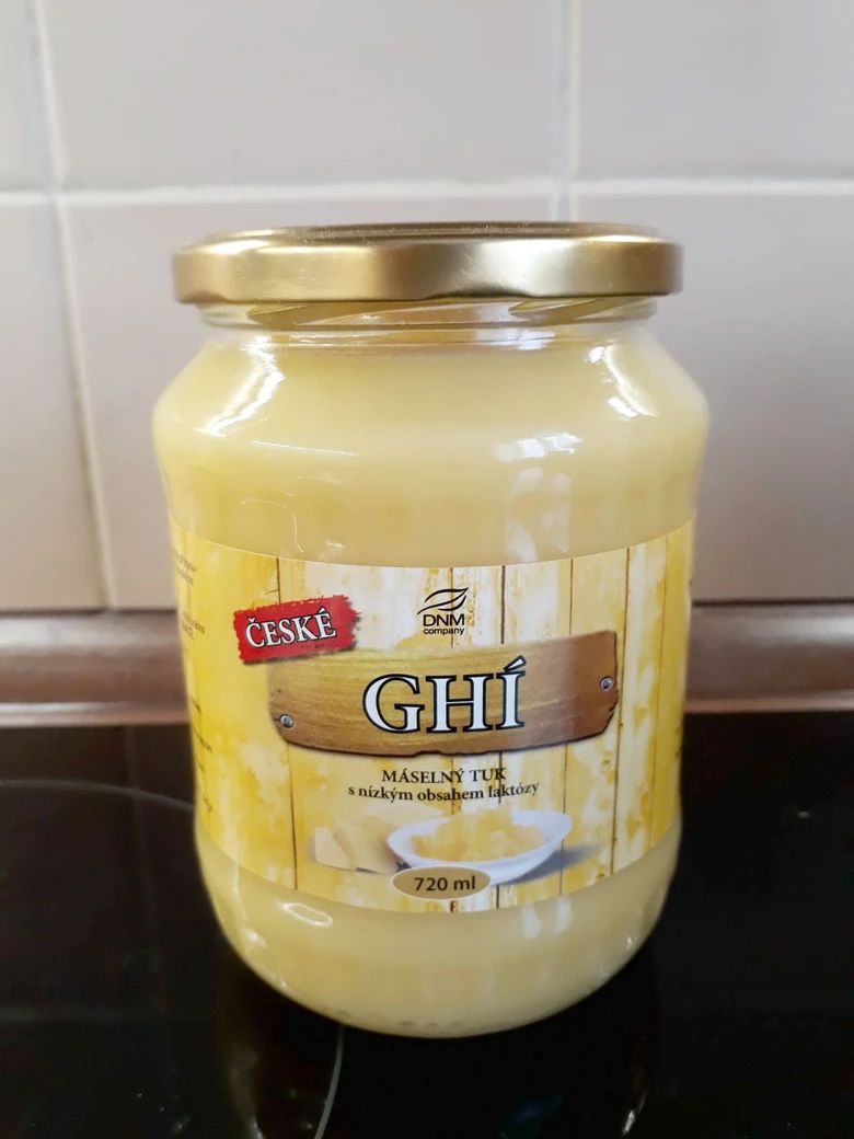 Skleněná nádoba s českým ghím na kuchyňské desce